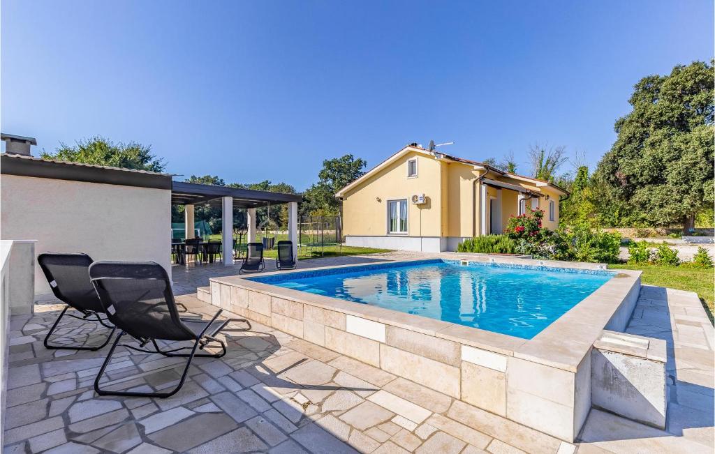 a swimming pool with two chairs and a house at Awesome Home In Valtura With Wifi in Valtura