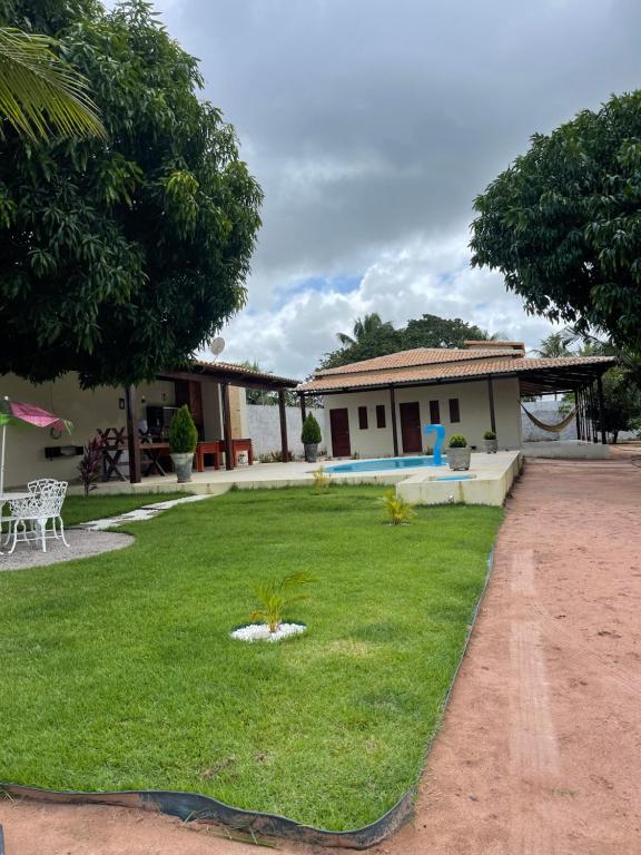 a house with a yard with a lawn sidx sidx sidx sidx at Pousada MKC in São Gonçalo do Amarante