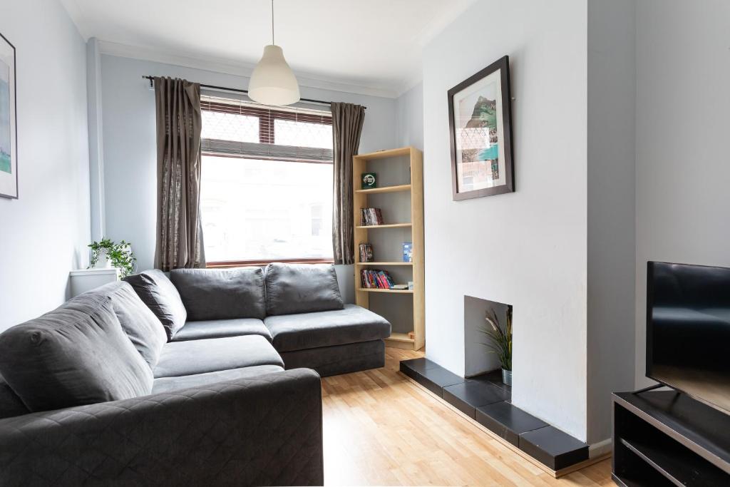 a living room with a couch and a tv at Belfast City - 3 Bedroom Cosy Home - Walking Distance to City in Belfast