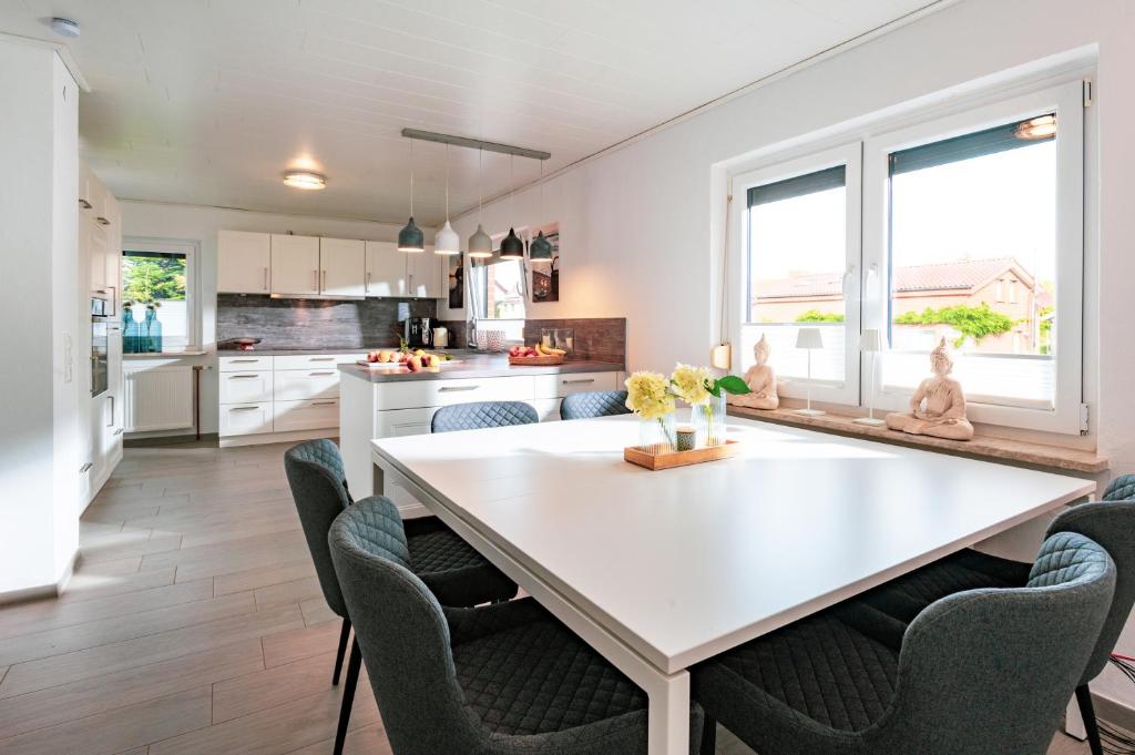 een keuken en eetkamer met een witte tafel en stoelen bij Ferienhaus Meergefühl in Neukirchen