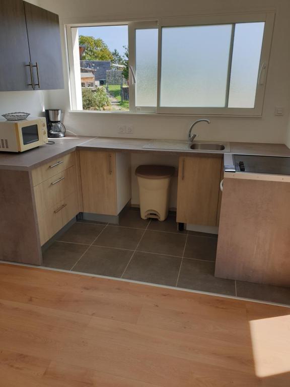 eine leere Küche mit einem Waschbecken und einem Fenster in der Unterkunft MAISON A in Saint-Jean-de-Thurigneux