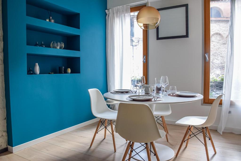 a dining room with blue walls and a white table and chairs at [Duomo Luxury Home * * * * *] San Paolo Cathedral in Treviso