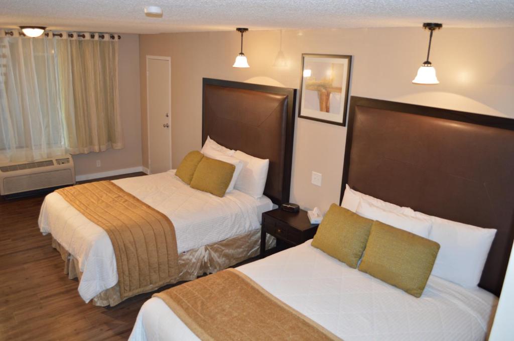 A bed or beds in a room at Laramie Valley Inn
