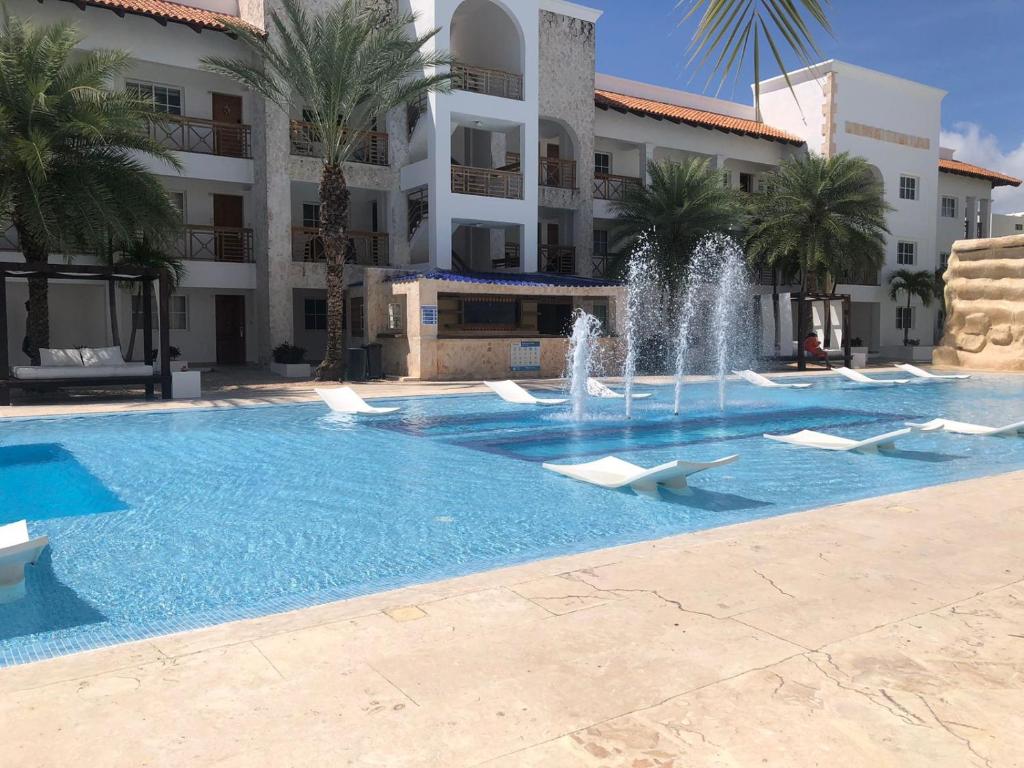 蓬塔卡納的住宿－Apto estudio en Punta Cana, vista a la pisicina，一座大楼前的游泳池,带喷泉