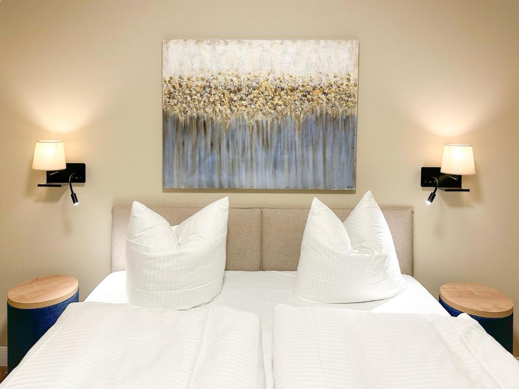 a bedroom with two white beds and two lamps at Appartements "Zum Leuchtturm" Hafen Rankwitz Insel Usedom in Rankwitz