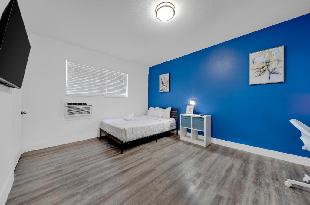 um quarto com uma cama e uma parede azul em Enchanting Studio in Little Havana em Miami