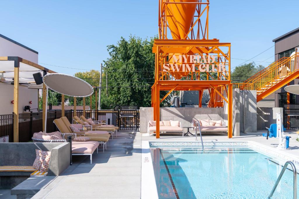 una piscina en un hotel con sillas y un cartel en The Myriad Hotel, en Louisville