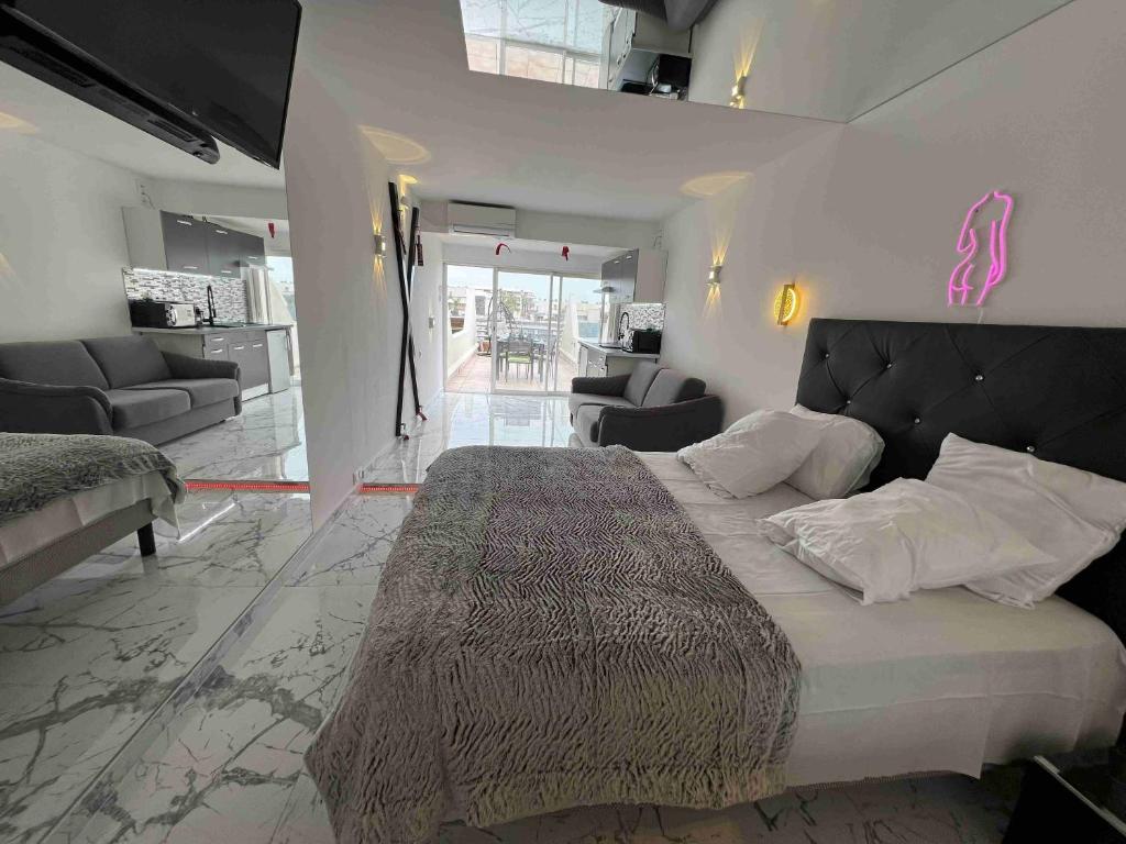 une chambre avec un grand lit et un salon dans l'établissement Fetish Studio, au Cap d'Agde