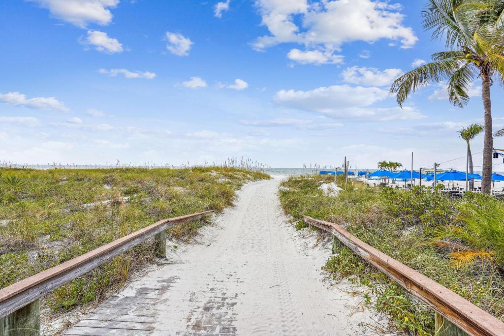 a dirt road through a beach with palm trees at Beach House on the Sand in St Pete Beach