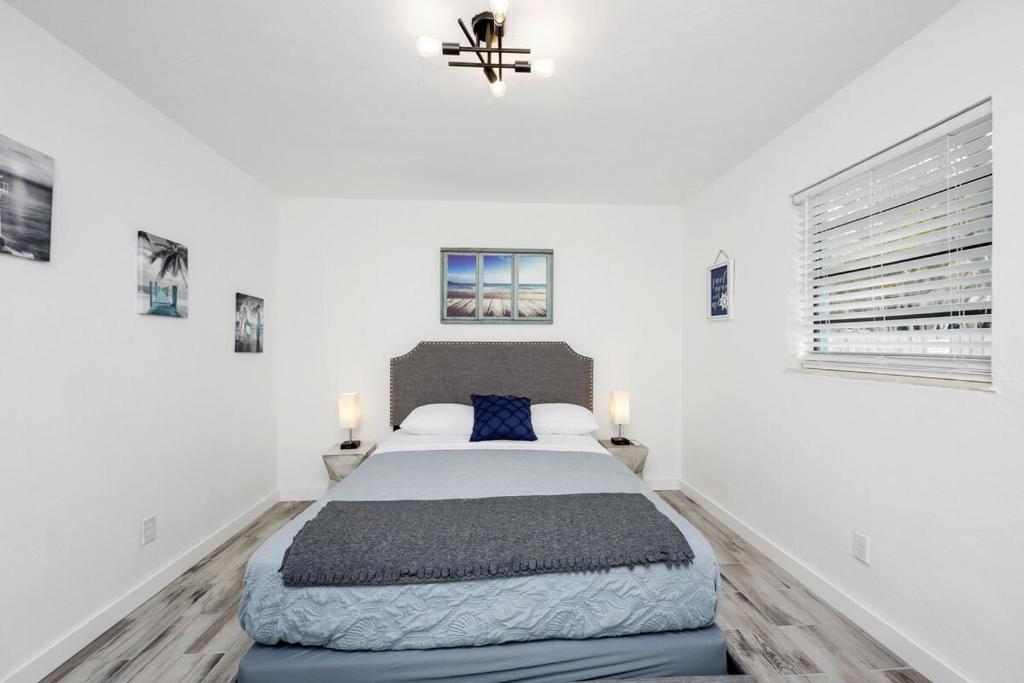 a bedroom with a large bed and two windows at Cozy 11 & Patio Near The Beach- Unit #3 in Hollywood