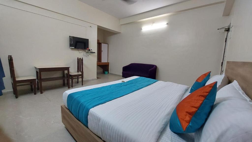 um quarto com uma cama, uma mesa e uma cadeira em Hotel great punjab em Aurangabad