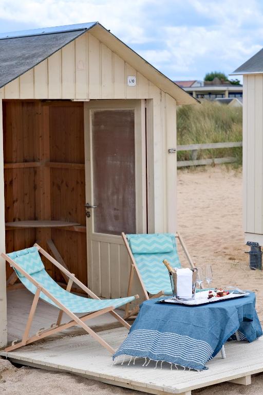 a table and a chair and a table and a building at Thalazur Ouistreham - Hôtel & Spa in Ouistreham