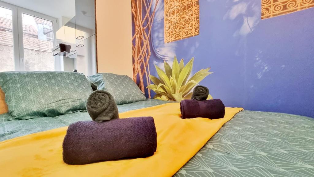 2 personnes assises sur un lit dans une pièce dans l'établissement La Résidence Évasion 1 - Original - Gare - Wifi - Relax BNB, à Mulhouse