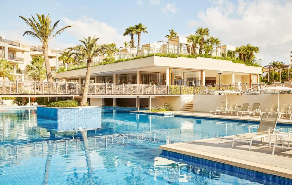 een resort met een zwembad en een gebouw bij Zafiro Palace Alcudia in Port d'Alcudia