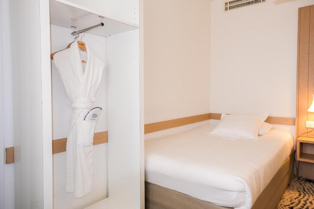 a small bedroom with a bed and a closet at Thalazur Ouistreham - Hôtel & Spa in Ouistreham