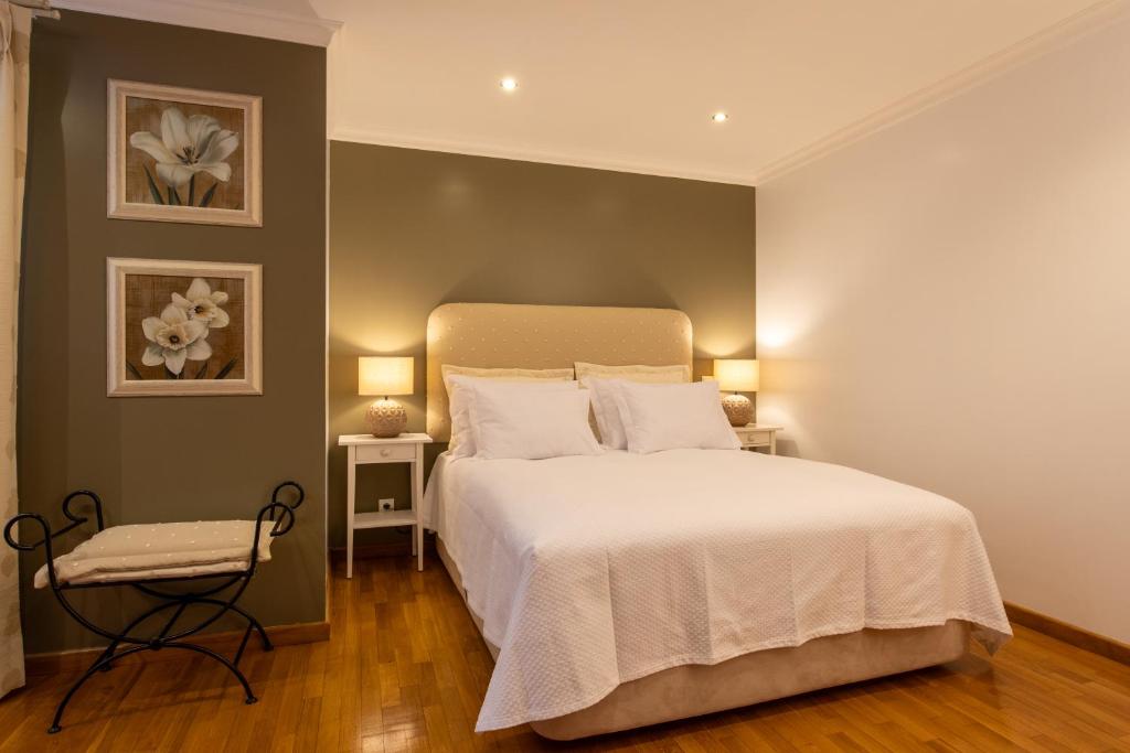 - une chambre avec un grand lit blanc et deux lampes dans l'établissement Miradouro da Penha, à Faro