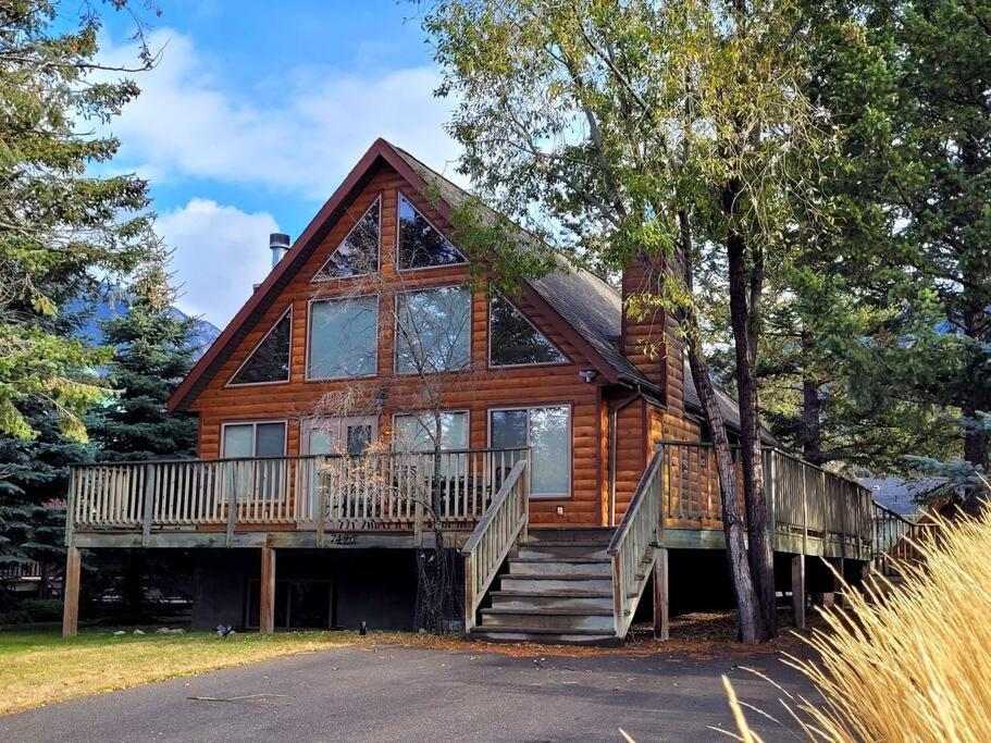 a large wooden house with a large deck and stairs at Pine Cone Cabin by FantasticStay in Radium Hot Springs
