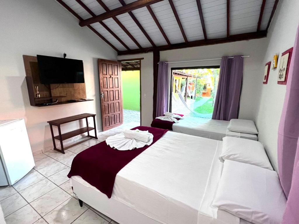 Una cama o camas en una habitación de Pousada Tropicália