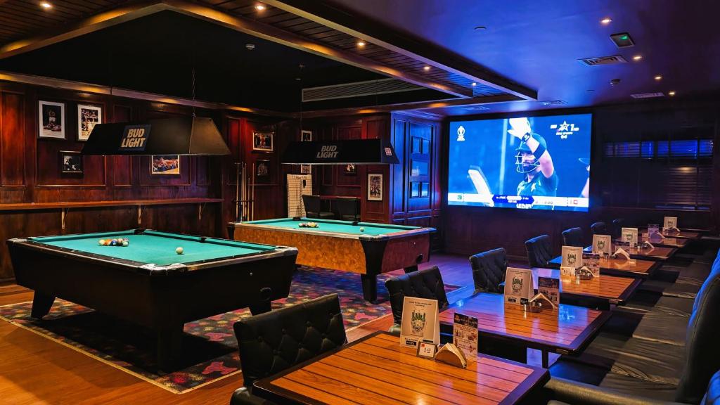 a poker room with pool tables and a tv at City Tower Hotel in Fujairah