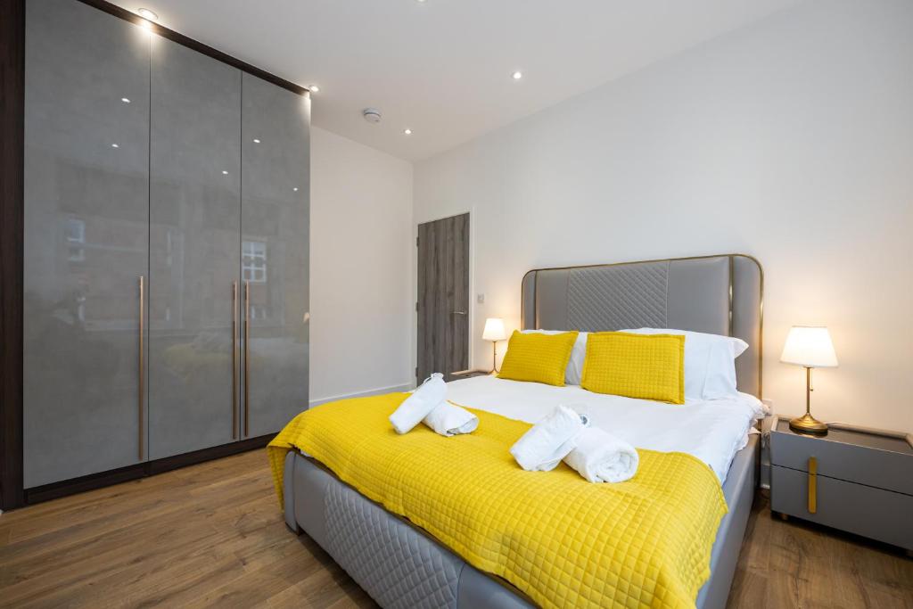 een slaapkamer met een geel bed en handdoeken bij Superb 2BD apartment in China Town in Manchester