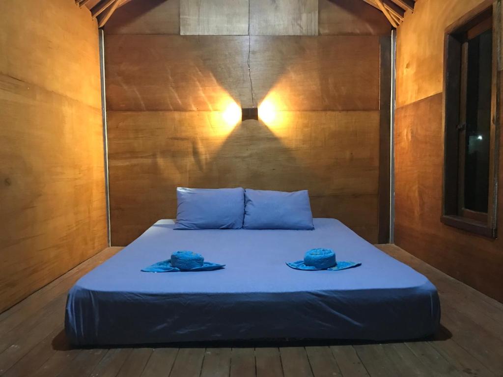 a bed in a room with two hats on it at Muni's Lombok Bungalow in Masbagik