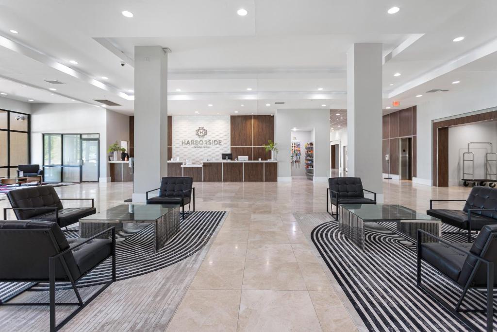 a waiting room with chairs and tables in a lobby at Harborside Hotel in Oxon Hill