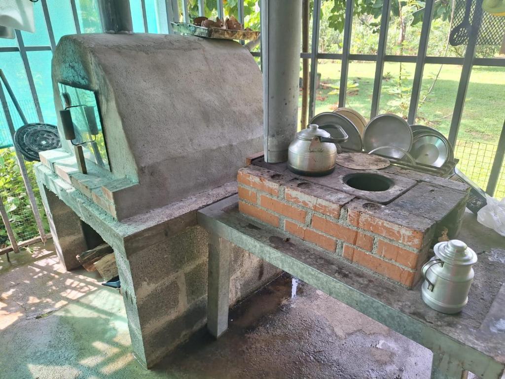 的住宿－POSADA VERDE，上面有锅和平底锅的旧砖炉