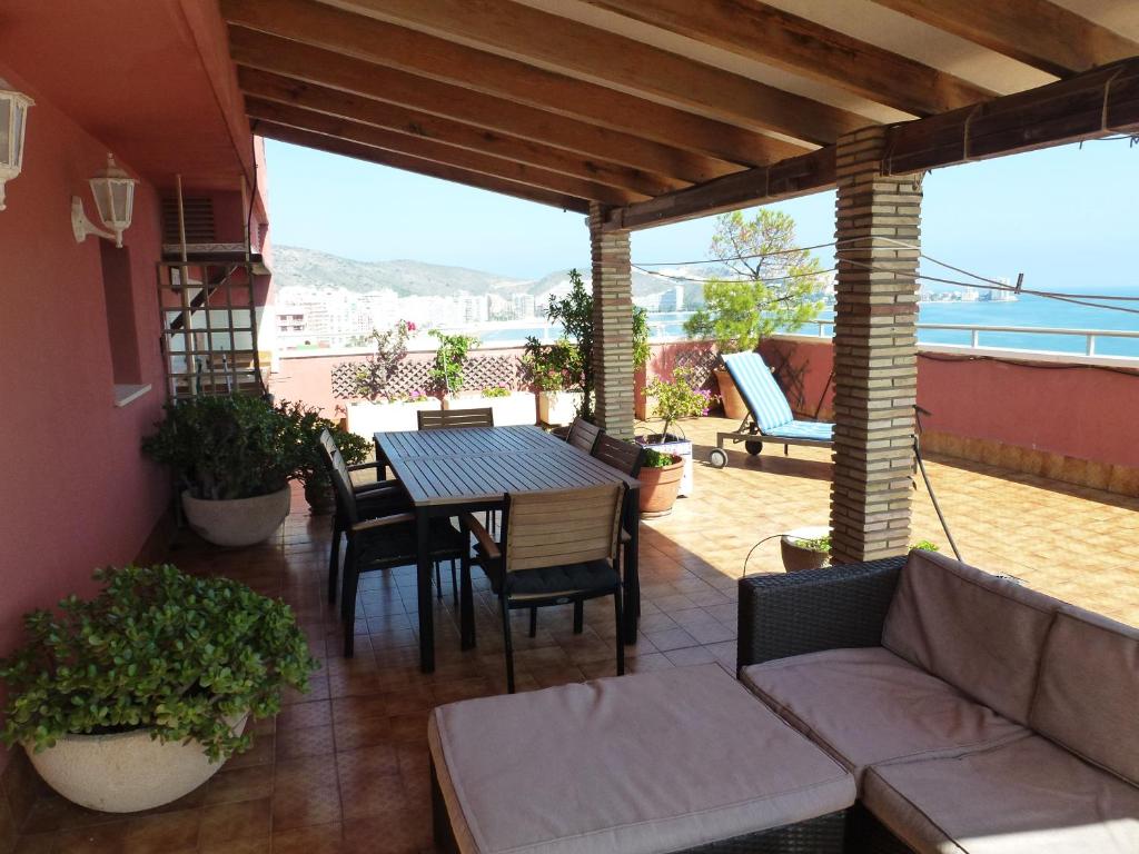 un patio con sofá, mesa y sillas en Espectacular terraza y vistas en 1a línea de playa, en Cullera