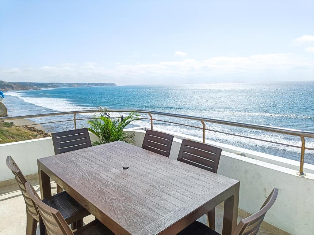 una mesa y sillas en un balcón con vistas al océano en Panoramic View to the ocean Manta en Manta