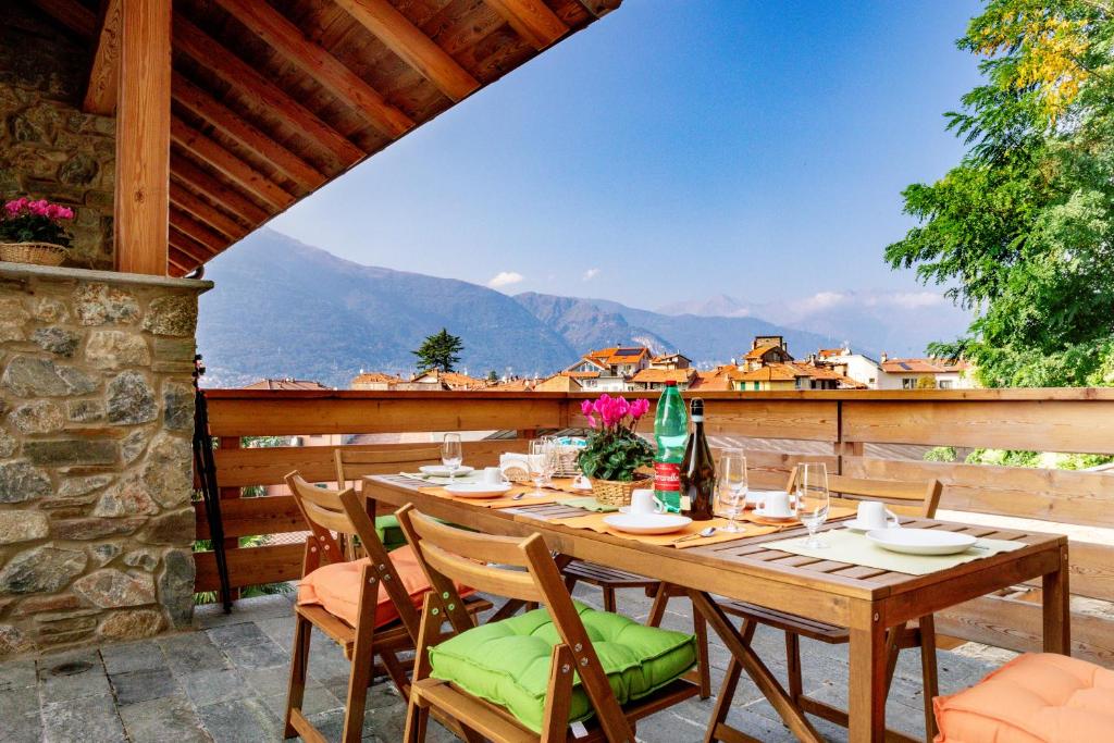 a table on a balcony with a view of mountains at Green Chalet Scalotta - Wonderful Terrace Lake and Mounts View in Dervio