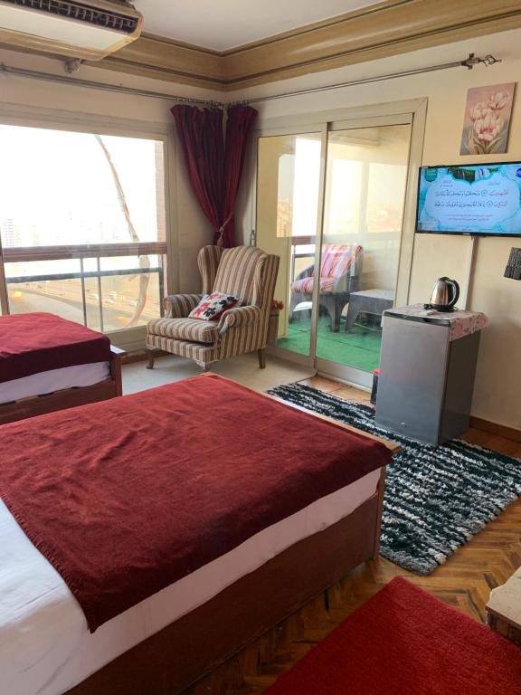 a hotel room with two beds and a television at Nile Star Suites & Apartments in Cairo