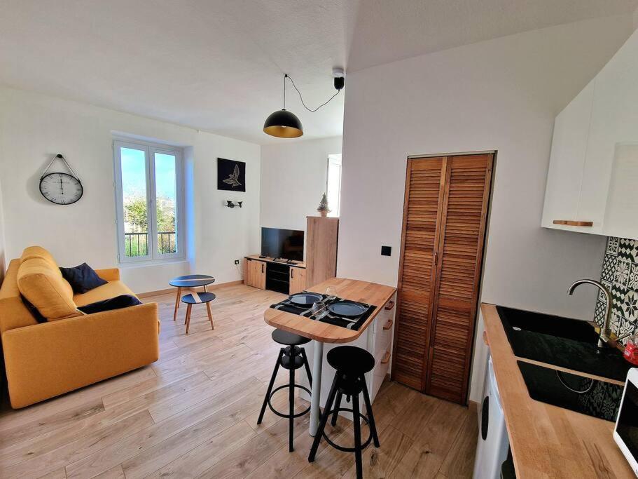 une cuisine et un salon avec un canapé et une table dans l'établissement Appartement jolie vue / proche rue de Siam, à Brest