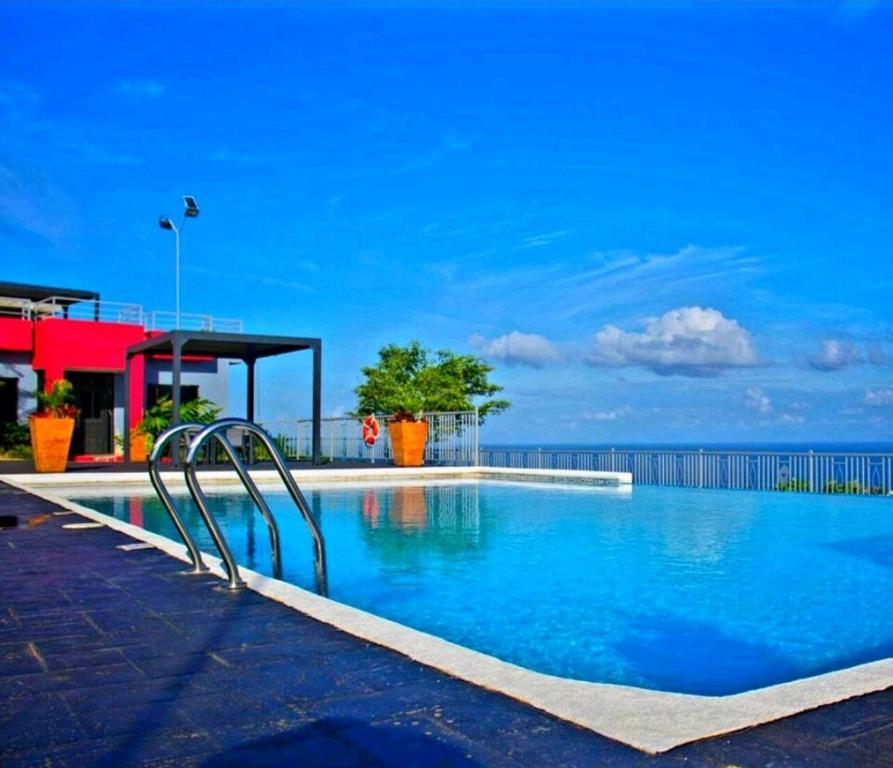 einen Pool mit blauem Wasser und Meer in der Unterkunft Lovely Memories Vacation Home in Ocho Rios