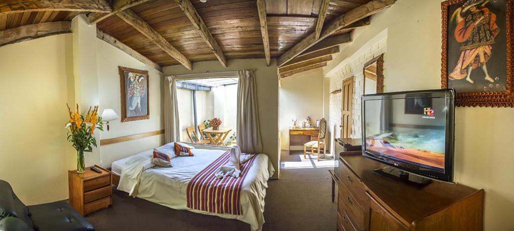1 dormitorio con 1 cama y TV de pantalla plana en Andean Dreams Hotel, en Cusco