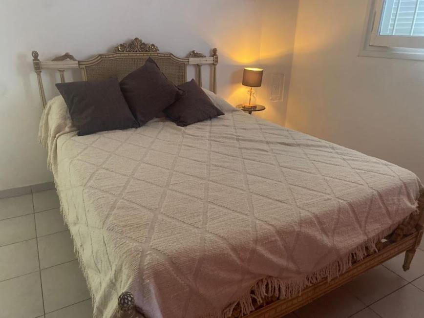 ein Schlafzimmer mit einem großen Bett mit einer weißen Bettdecke in der Unterkunft DEPARTAMENTO VINTAGE 2 HABITACIONES 2 BAÑOS LiVING COMEDOR COCINA A 2 CUADRAS PEATONAL CENTRO SAN JUAN in San Juan