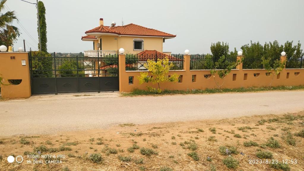 een huis met een hek voor een weg bij Villa Zeus Thessalonikis in Agia Triada