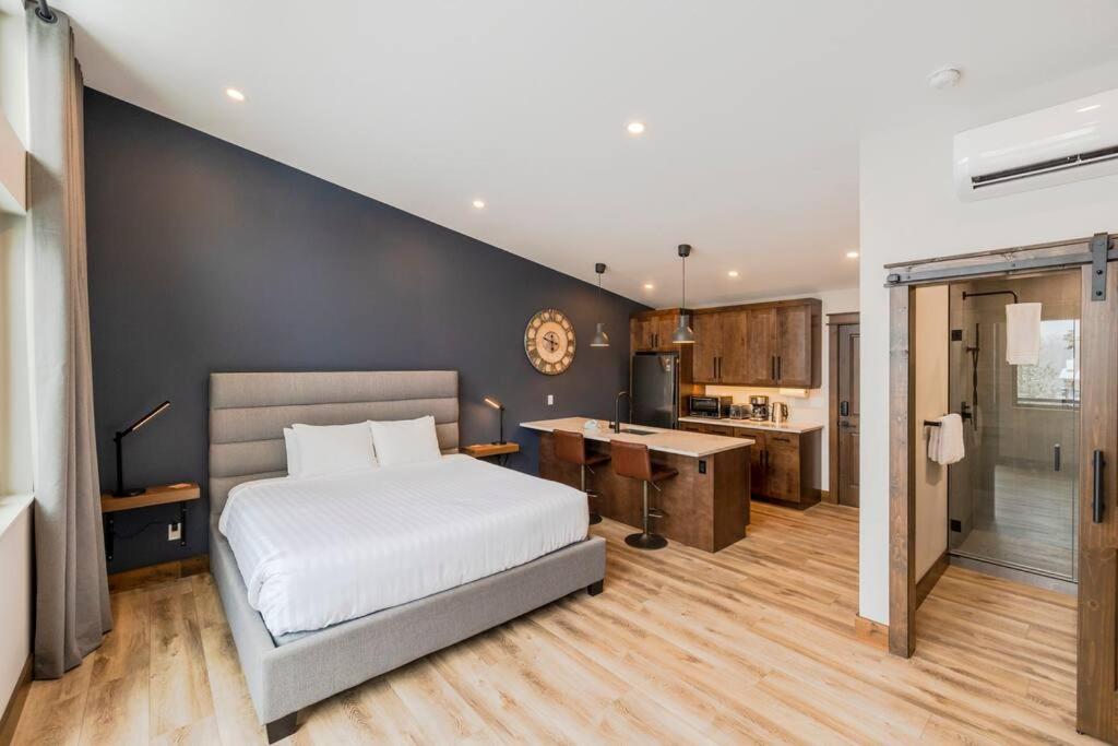 a bedroom with a large bed and a kitchen at 22 Sunniva by FantasticStay in Fernie