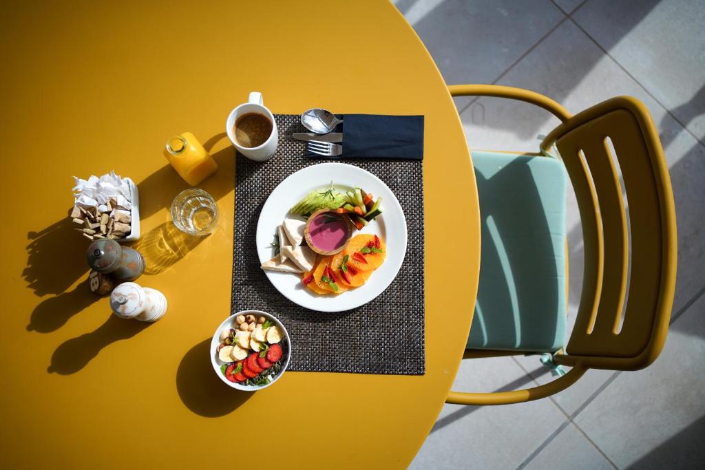 a yellow table with a plate of food on it at INNSiDE by Meliá Fuerteventura – Adults Only in Costa Calma