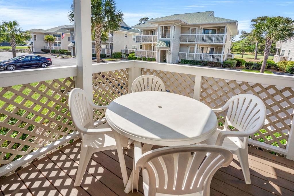 - Balcón con mesa y sillas blancas en Shorehaven 16B, en Myrtle Beach