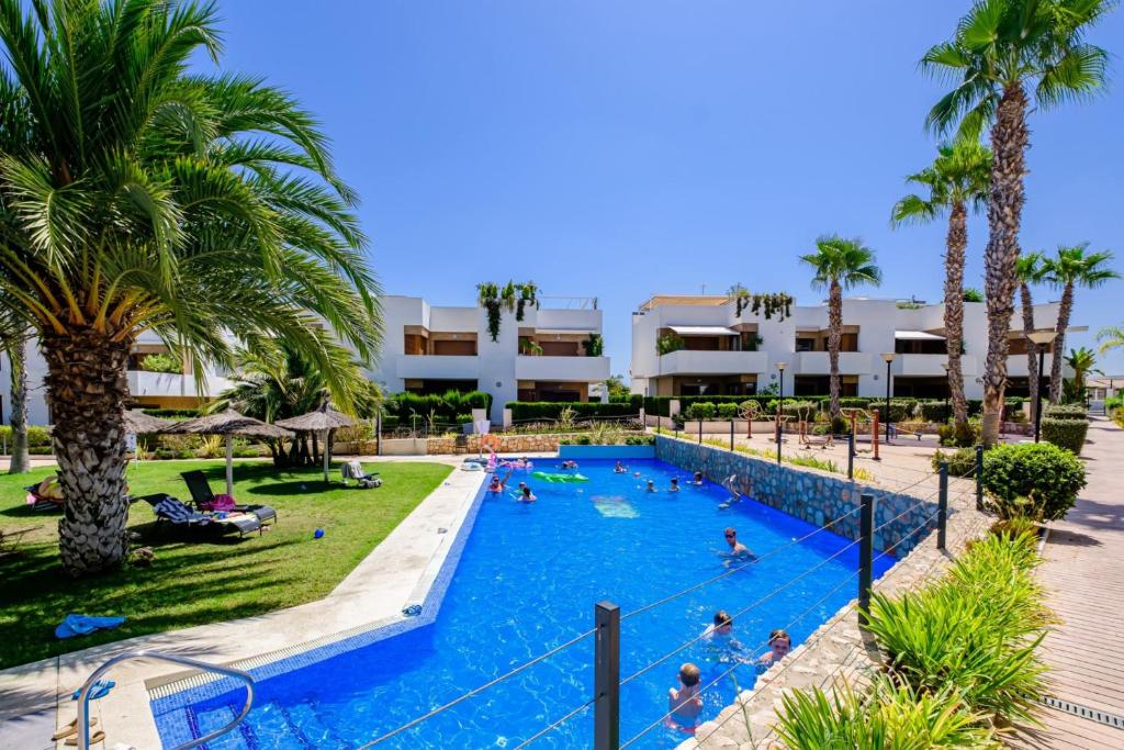 uma piscina num resort com pessoas em Secreto De La Zenia ID200 em Playa Flamenca