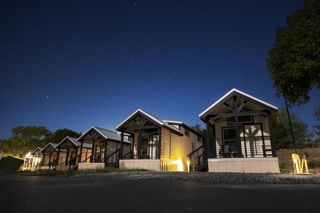 a row of houses lit up at night at HTR TX Hill Country Campground in Kerrville