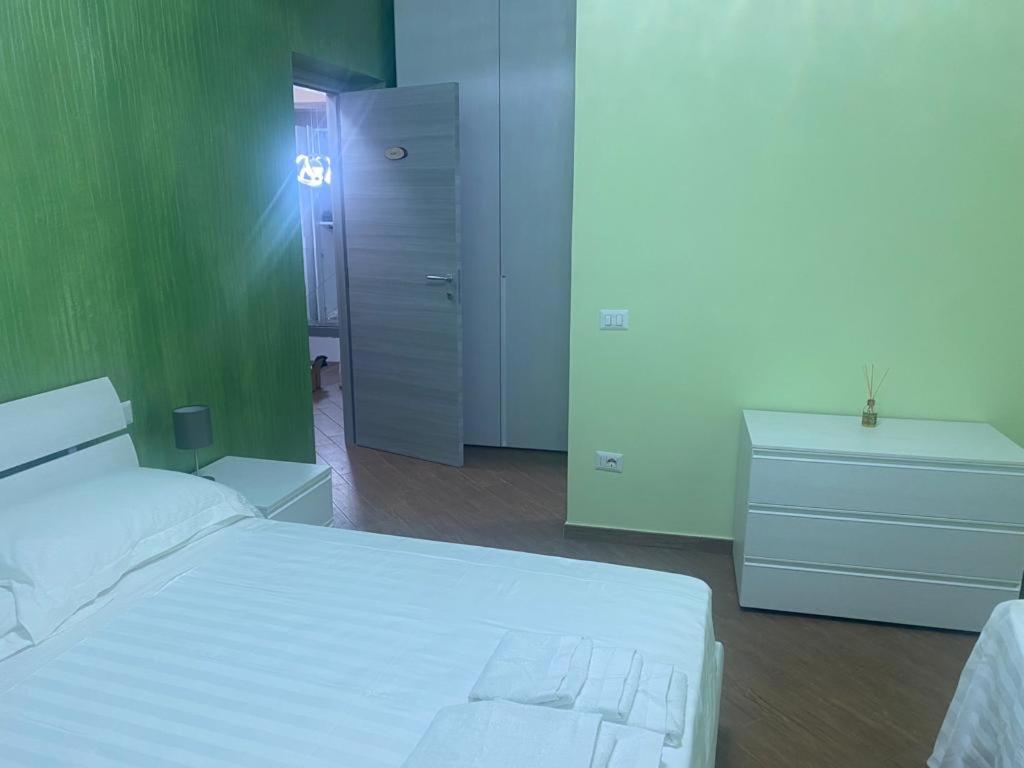 a bedroom with a white bed and a green wall at Al Romito in Santo Padre