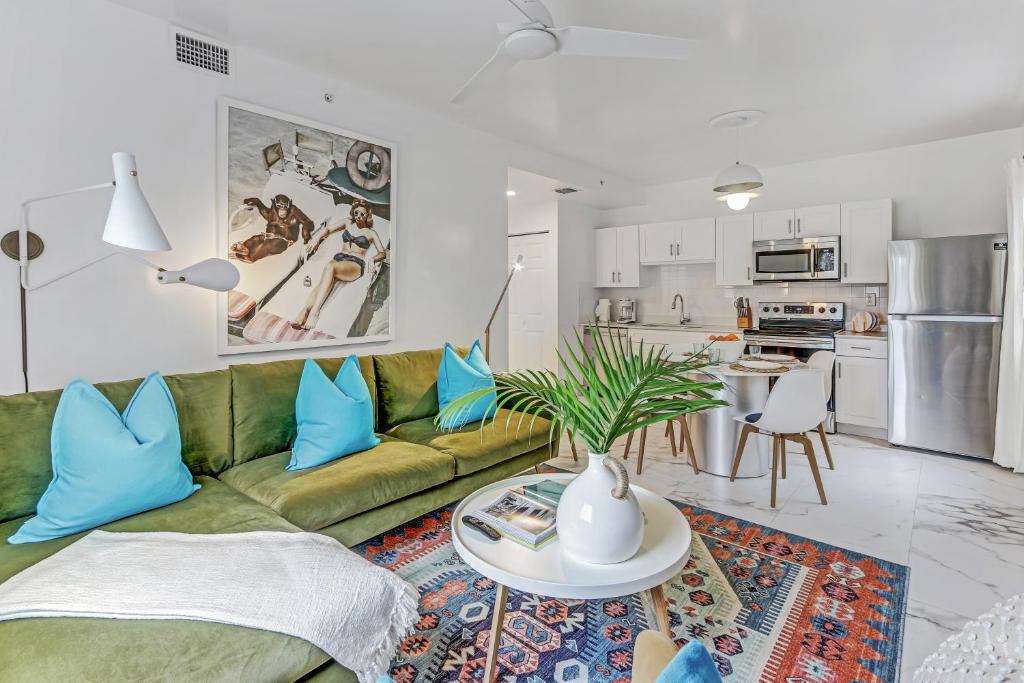 uma sala de estar com um sofá verde e almofadas azuis em ArTease5 - stylish, near Wynwood Walls & restaurants em Miami