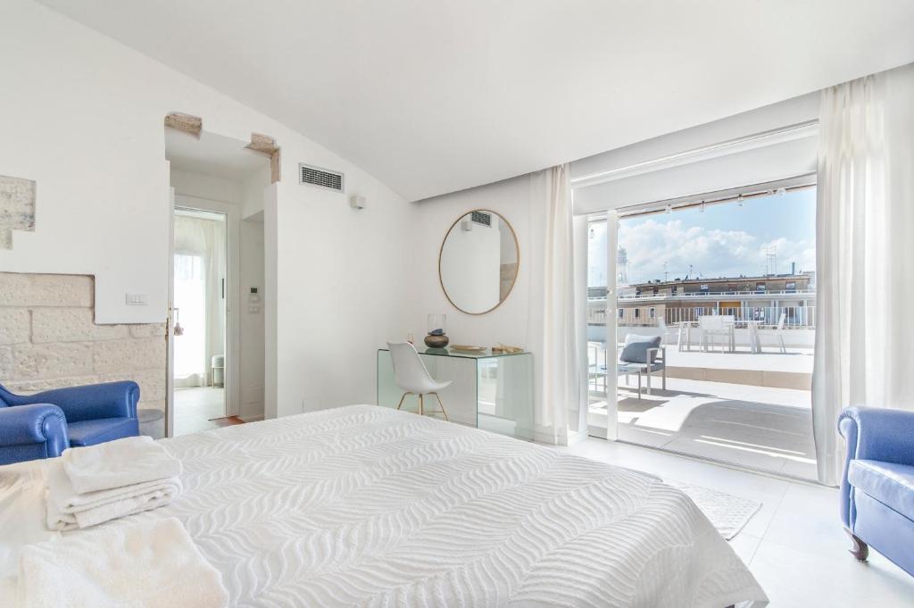 レッチェにあるTerrazza Sant'Oronzoの白いベッドルーム(大型ベッド1台、バルコニー付)