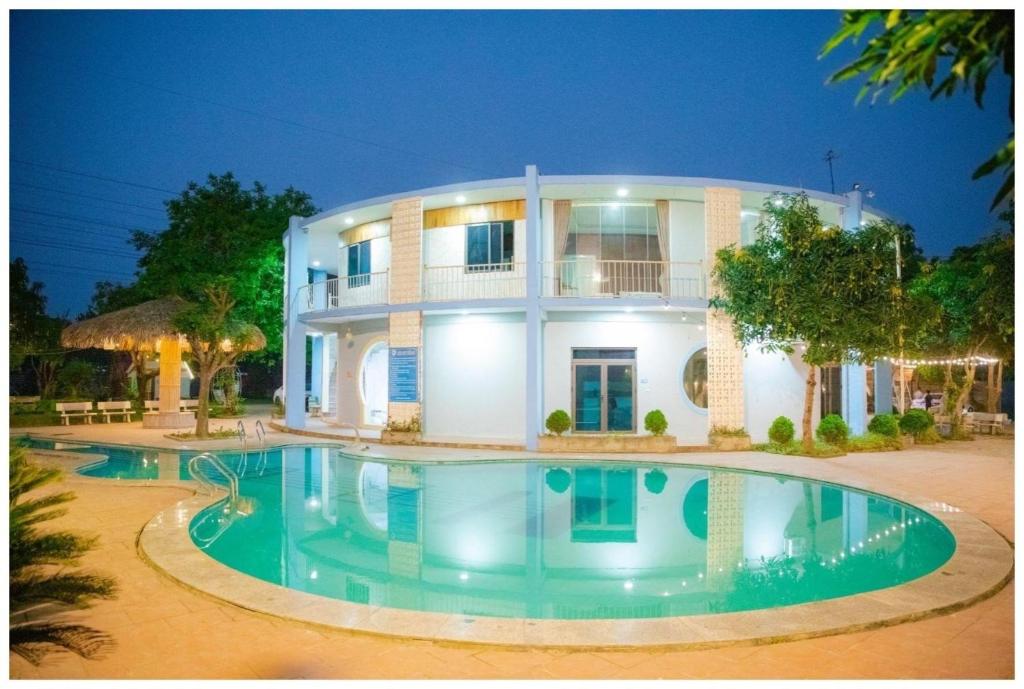 een groot huis met een zwembad ervoor bij Biển Đông COMPLEX in Lương Sơn