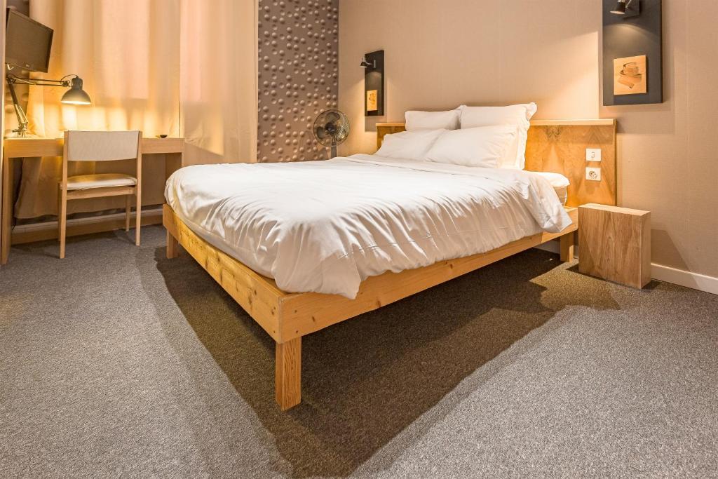 Un pat sau paturi într-o cameră la Résidence L'Atelier