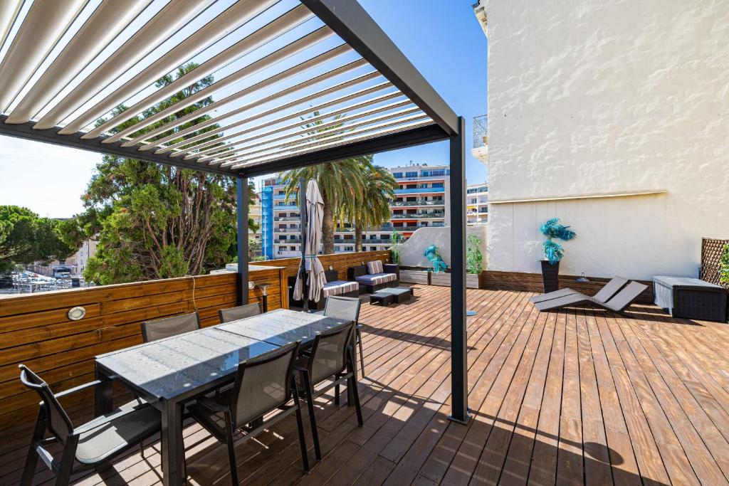 eine Terrasse mit einem Tisch und Stühlen auf einer Terrasse in der Unterkunft Superb 68m2 flat with 80m2 terrace - 2Ch4p in Cannes