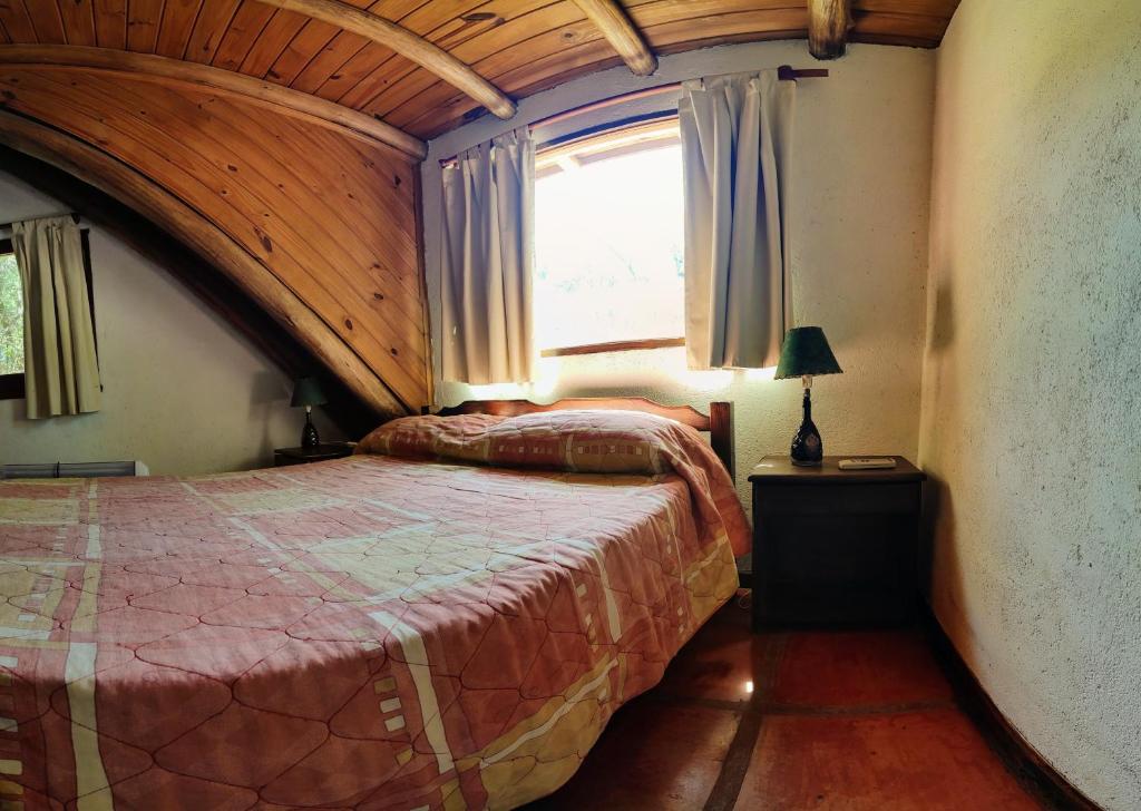 1 dormitorio con 2 camas en una habitación con ventana en Cabañas Budapest en Capilla del Monte