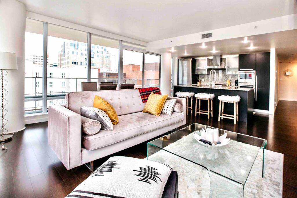 ein Wohnzimmer mit einem Sofa und einer Küche in der Unterkunft Victoria's best location 2 bedroom luxe condo in Victoria