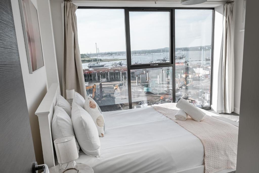 a bedroom with a large bed with a large window at No Seven Harbour Side in Poole